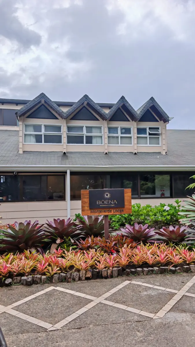 The Monteverde Lodge building and sign, with bromeliads in front