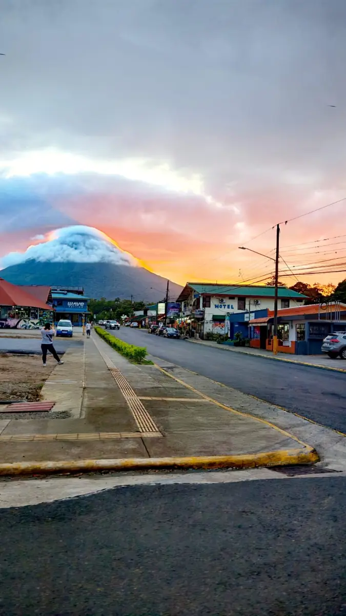 La calle principal de La Fortuna al atardecer, con el volcán Arenal