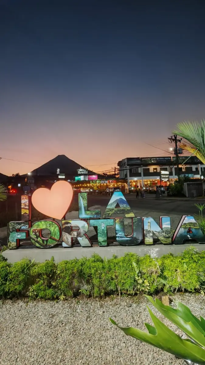 The I ♥ La Fortuna letters at dusk, with Arenal volcano behind