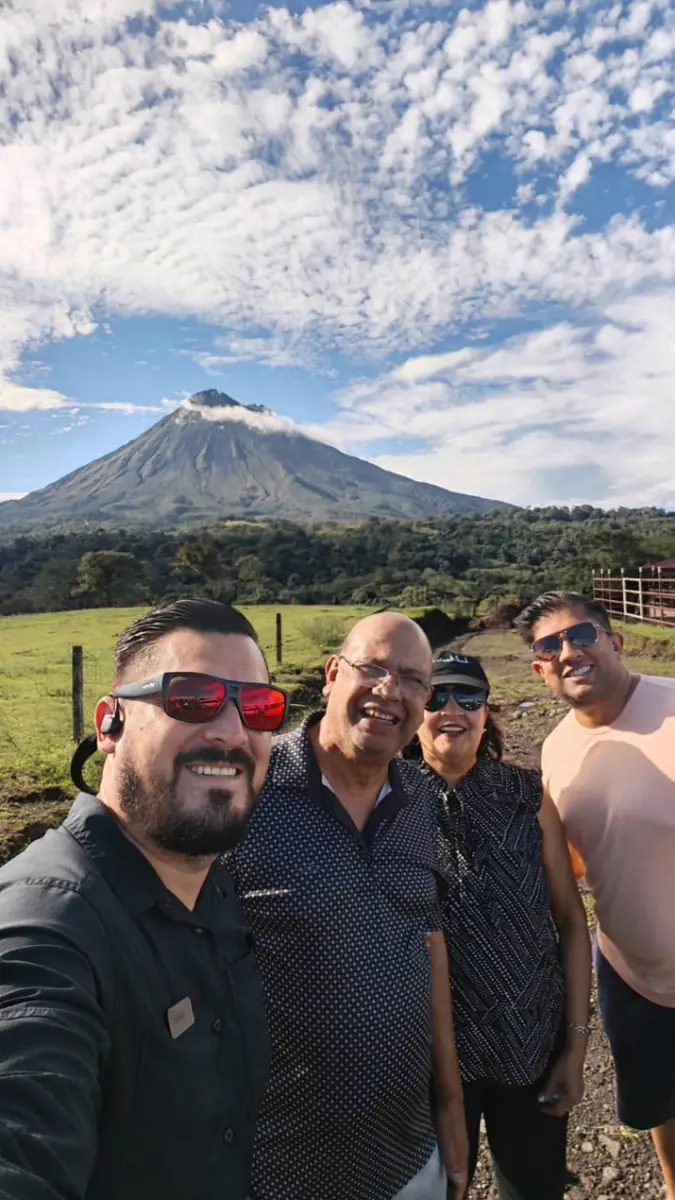 Travellers with their driver in front of Arenal volcano