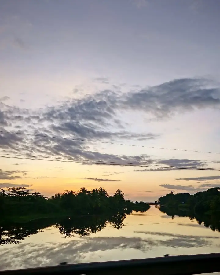 Río en calma al amanecer camino al Caribe Sur, reflejando el cielo
