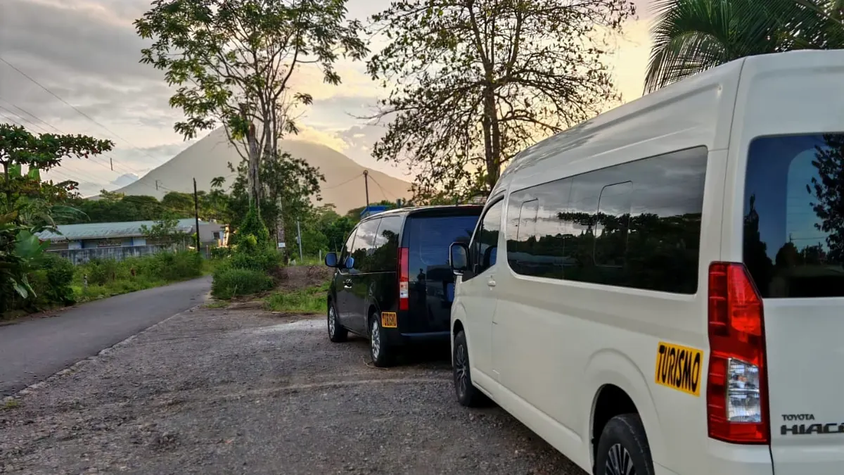Las busetas de Tropical Experts al atardecer con el volcán Arenal