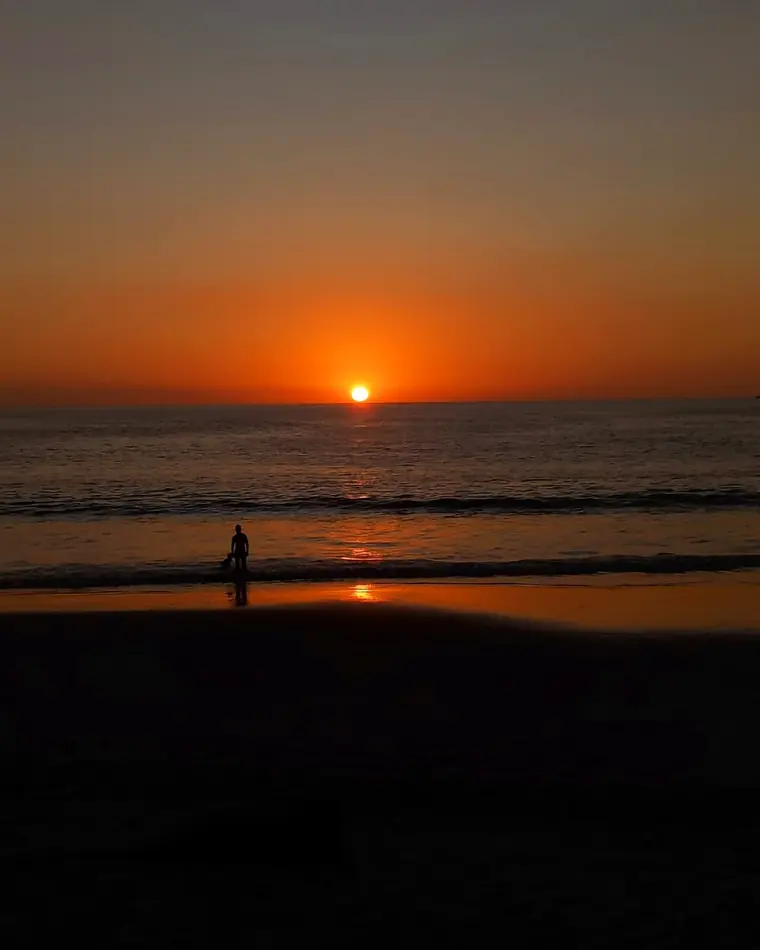 Atardecer naranja en Tamarindo con una persona en la orilla