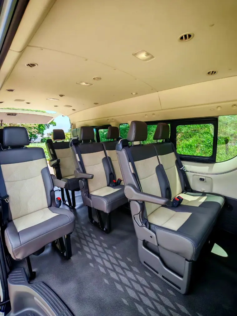 Interior de una buseta de turismo con asientos reclinables individuales