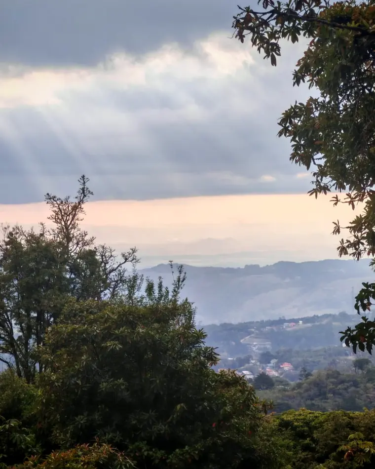 Santa Elena de Monteverde vista desde lo alto al atardecer, con rayos de sol y el golfo al fondo