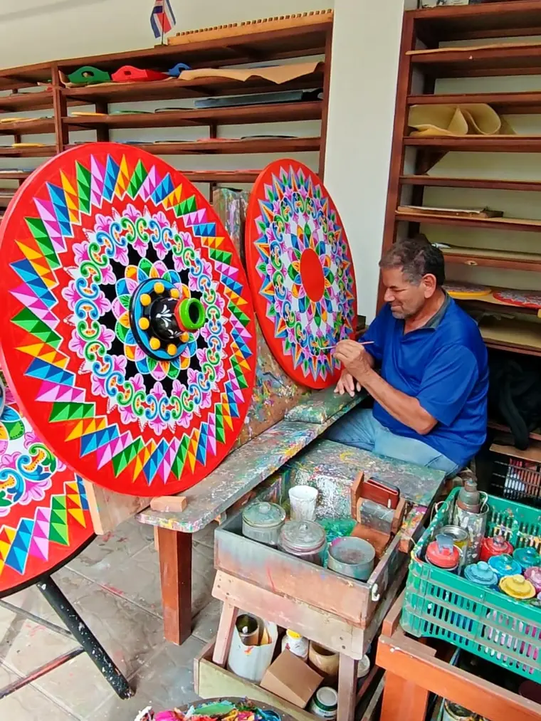 Pintor de Sarchí decorando a pulso una rueda de carreta