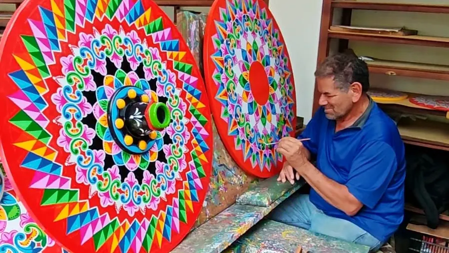 Pintor de Sarchí decorando ruedas de carreta a pulso