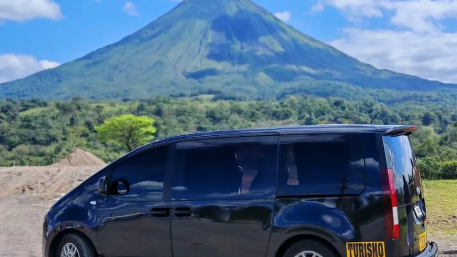 Buseta de turismo de Tropical Experts con el volcán Arenal detrás