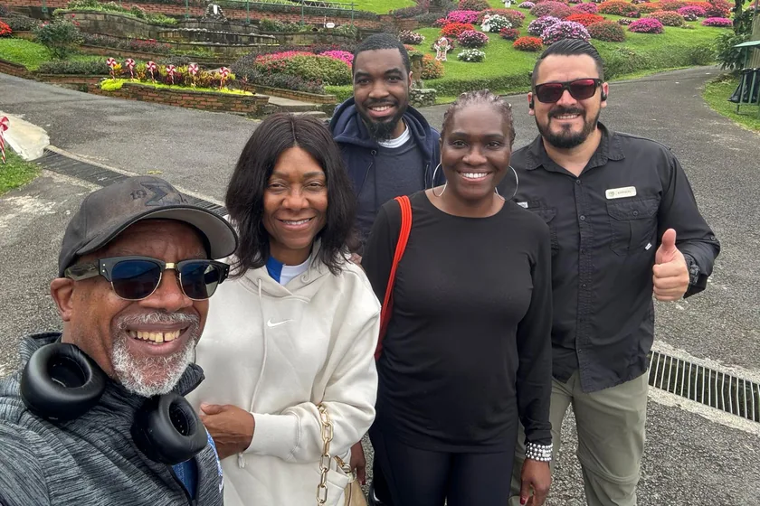 Familia de pasajeros con Johnson en un jardín de flores, durante una parada del traslado
